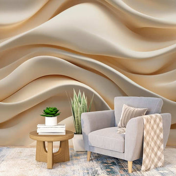 Фототапет за хол вълни от нежност с нежни бежови форми на стената зад комфортно кресло.