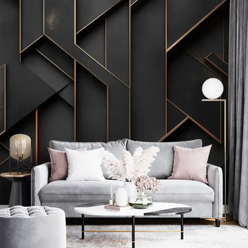 Stylish living room with black and gold geometric wallpaper, gray sofa, and elegant decor elements.